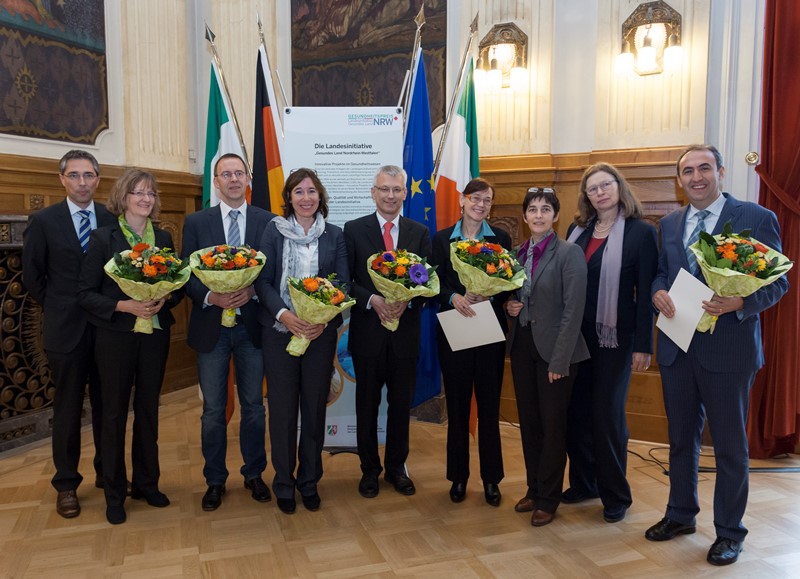 Gruppenbild aller Preisträgerinnen und Preisträger 2013 mit Ministerin Barbara Steffens (3. v. r.) sowie der Regierungspräsidentin Anne Lütkes (2. v.