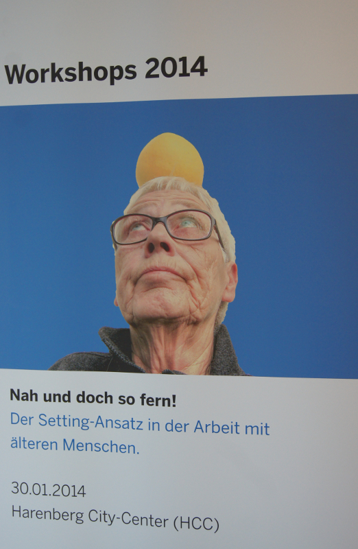 Das Veranstaltungsbanner zeigt eine ältere Frau mit einer Zitrone auf dem Kopf.
